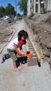 child "helping" to build retaining wall